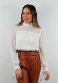 Blusa blanca con pliegues, mangas con lazos en los puños y escote con abertura