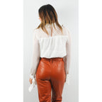 Blusa blanca con pliegues, mangas con lazos en los puños y escote con abertura